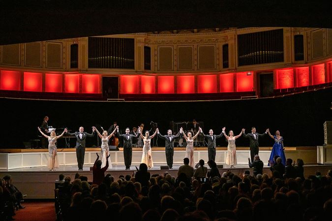 the full company of dancers and musicians takes a bow as the audience rises to its feet