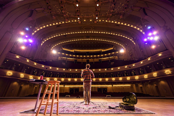 a view from the stage behind Chris Thile as he rehearses for his Symphony Center show