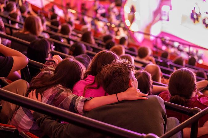 audience members with arms around each other