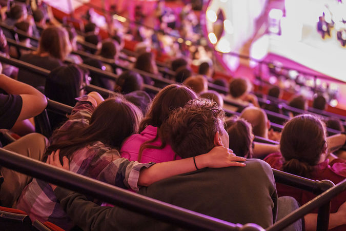 audience members with arms around each other