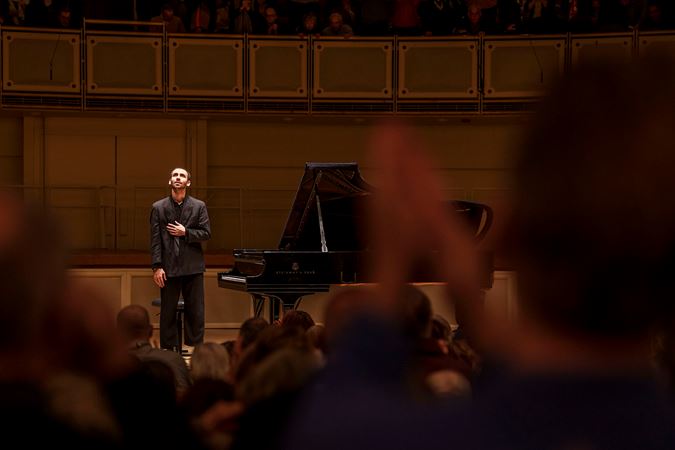 Alexandre Kantorow bowing on stage as the audience applauses