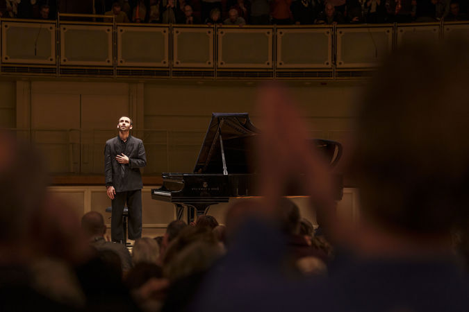 Alexandre Kantorow bowing on stage as the audience applauses