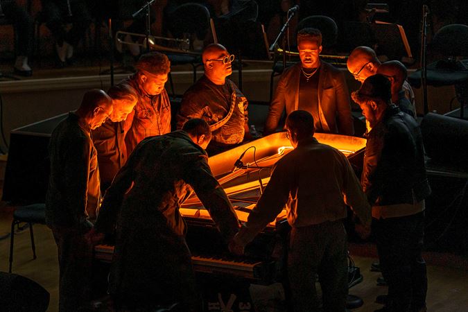 Jason Moran and fellow musicians in a prayer circle around a piano