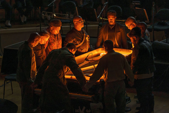 Jason Moran and fellow musicians in a prayer circle around a piano
