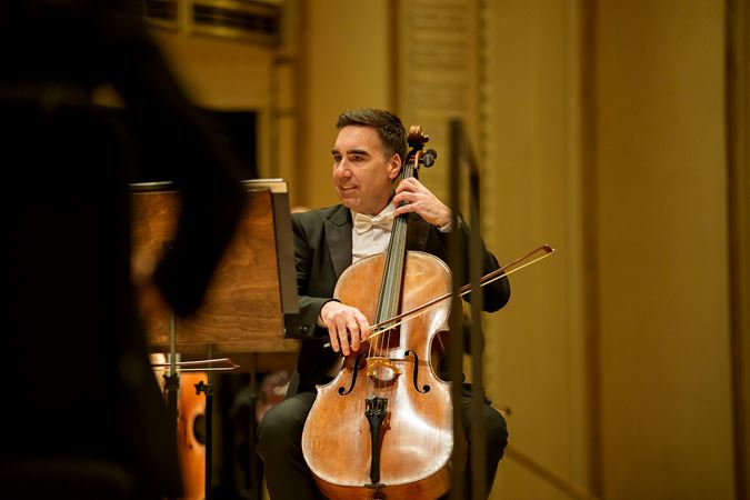 Closeup action shot of CSO assistant principal cello Kenneth Olsen performing on stage