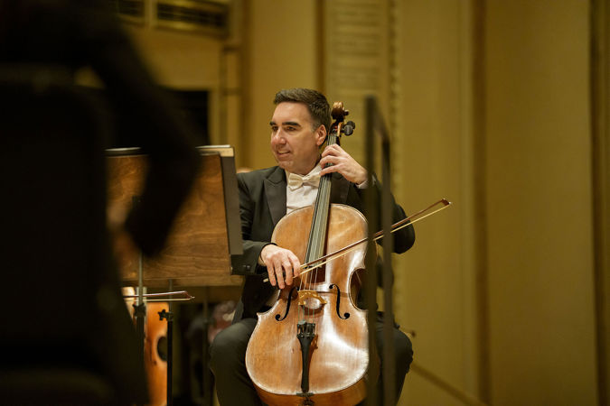 Closeup action shot of CSO assistant principal cello Kenneth Olsen performing on stage
