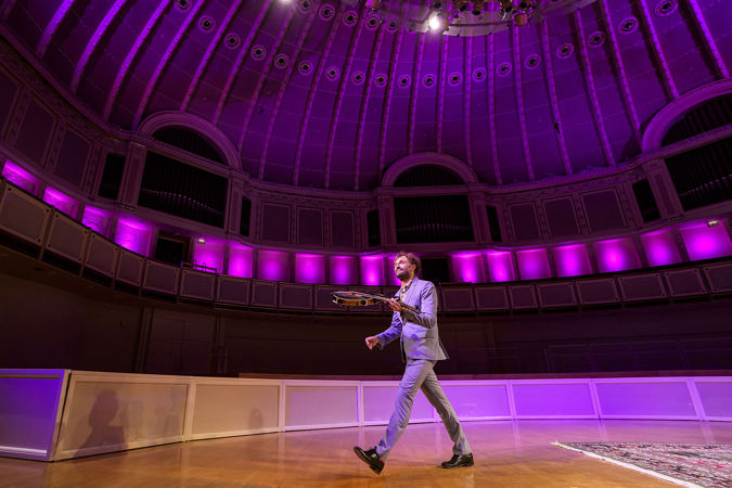Chris Thile walks off stage after his final bow, mandolin swinging in his left hand