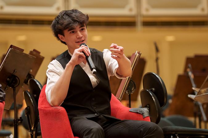2025 Young Artists Competition finalist Joseph Gallwas speaking with the audience during a postconcert Q&A session