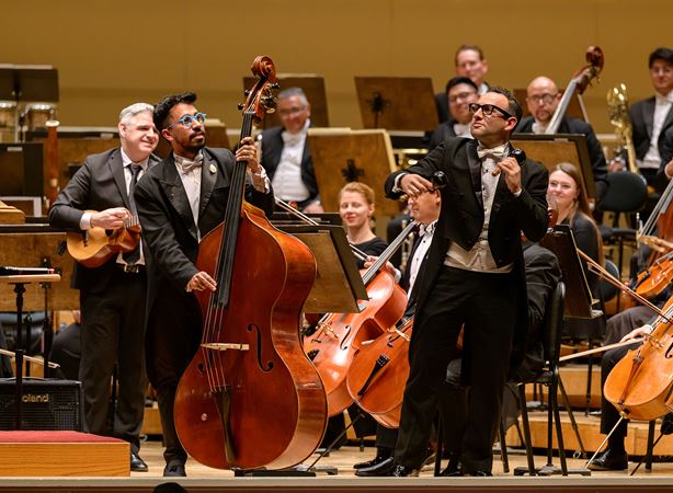 a bass player and a percussionist from the Sinfónica de Minería step forward for a duet during Paquito D'Rivera's Concerto Venezolano