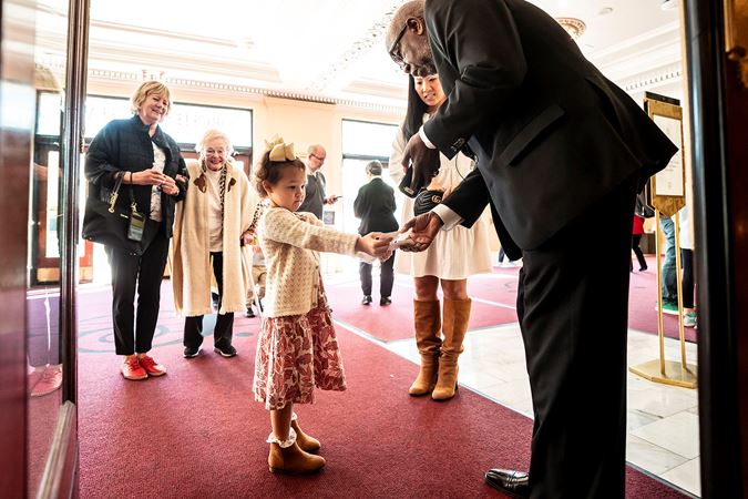 girl handing ticket to usher