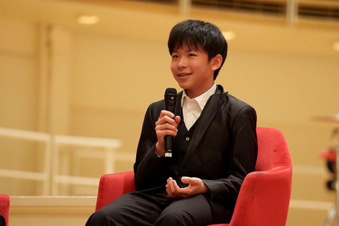 2025 Young Artists Competition winner Jeremy Liu speaking on stage at a postconcert Q&A session