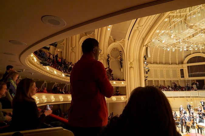 audience members in the box level give a standing ovation