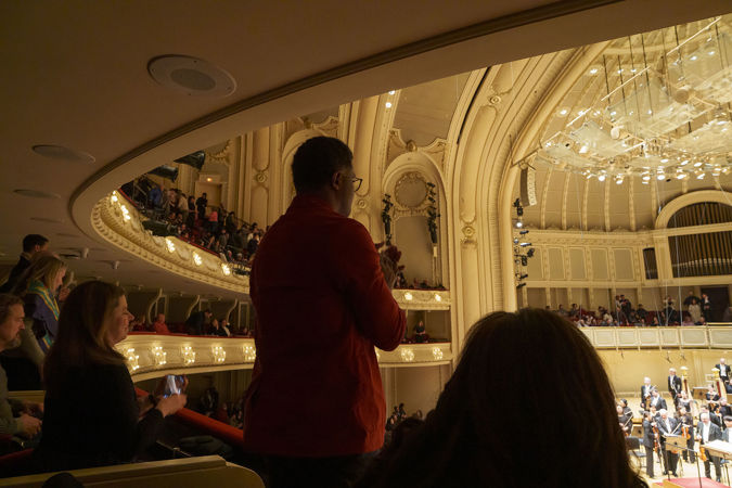 audience members in the box level give a standing ovation