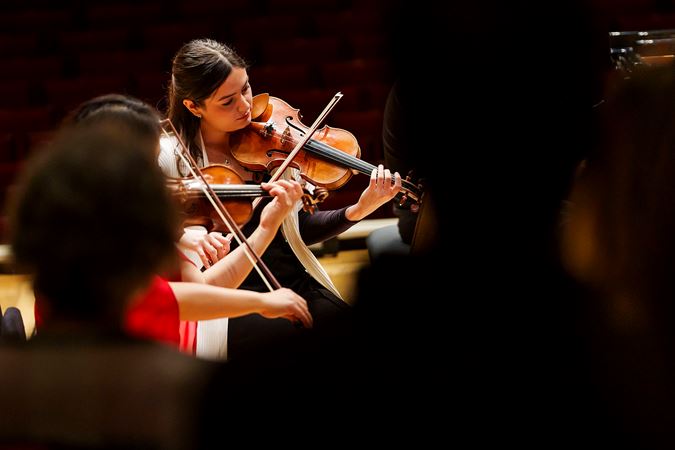 Closeup of CSO violin Gabriela Lara performing on stage