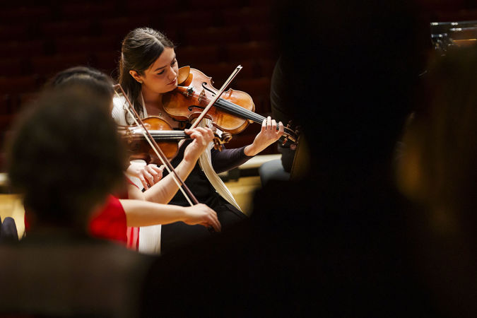 Closeup of CSO violin Gabriela Lara performing on stage