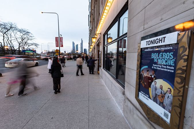 Michigan Avenue bustles with audience members passing through the doors to Orchestra Hall in front of the Boleros de Noche poster