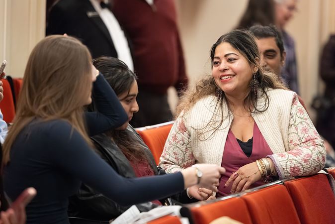 a group of audience members chat in their seats before the concert begins
