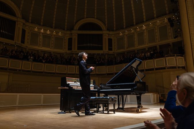 Hayato Sumino bows on stage as the crowd gives a standing ovation