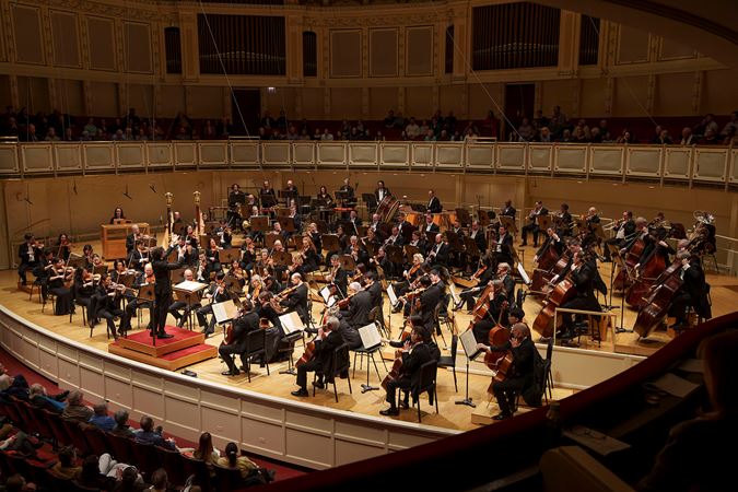 a view of the full Orchestra performing from the right side of the box level