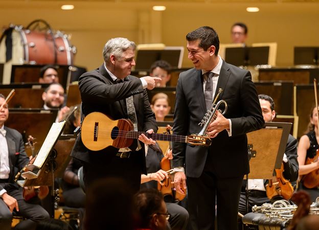Venezuelan cuatro player Héctor Molina and trumpet soloist Pacho Flores beam at one another after a triumphant performance
