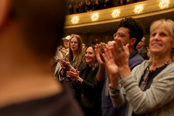 Closeup shot of audience members applauding violinist Augustin Hadelich, guest conductor Philippe Jordan and the CSO