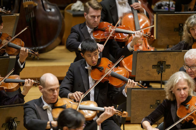 Closeup action shot of CSO viola Danny Lai performing on stage