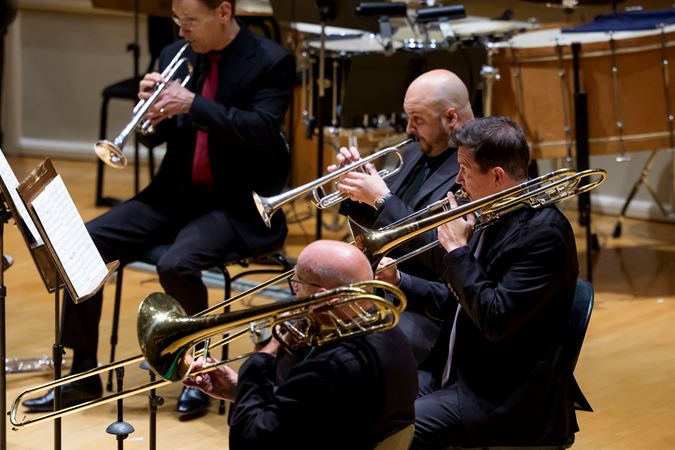 Closeup action shot of CSO musicians Charles Vernon (trombone), Timothy Higgins (trombone) and Esteban Batallán performing on stage