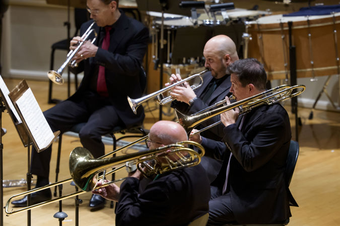 Closeup action shot of CSO musicians Charles Vernon (trombone), Timothy Higgins (trombone) and Esteban Batallán performing on stage