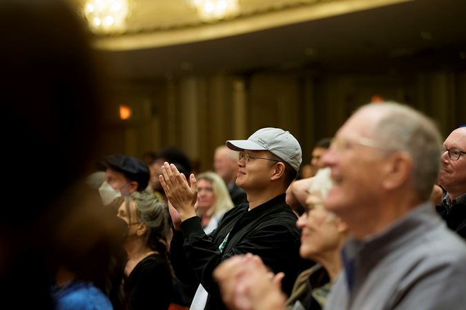 Closeup of a patron applauding all the musicians and Mikko Franck after the final note from the Main Floor