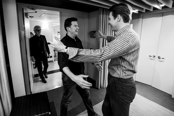 Klaus Mäkelä greets CSO principal trombone Timothy Higgins in the conductor's studio (black and white)