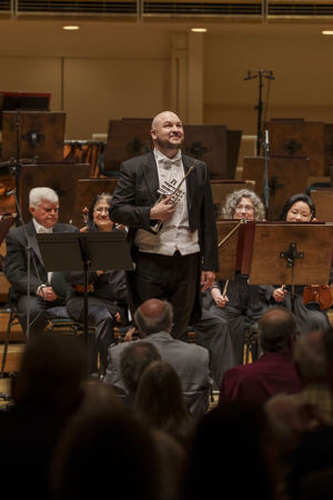 CSO principal trumpet Esteban Batallán bowing on stage