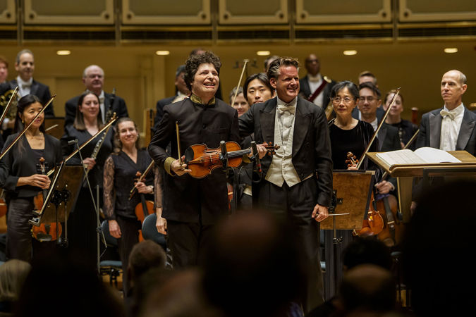 Closeup bow shot of violinist Augustin Hadelich and guest conductor Philippe Jordan on stage