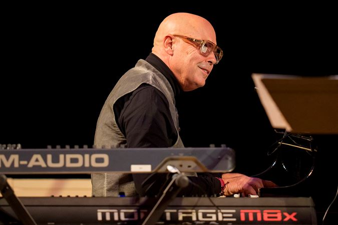 pianist and bandleader John Beasley smiles as he performs with his ensemble, Unlimited Miles