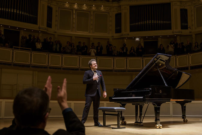 Benjamin Grosvenor accepts a standing ovation with a sincere smile and a hand on his heart