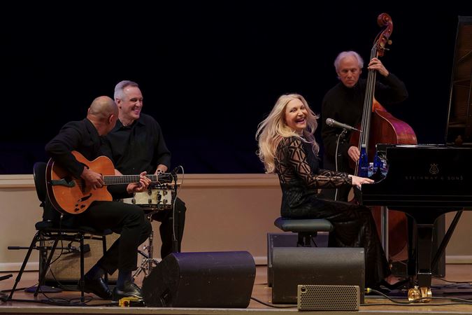 Brazilian vocalist and pianist Eliane Elias plays and sings as her quartet surrounds her, joyous expressions on their faces as they perform at Symphony Center