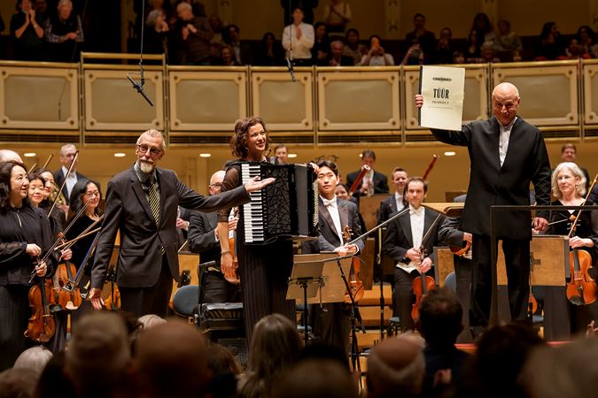 left to right, composer Erkki-Sven Tüür, accordion soloist Ksenija Sidorova, and conductor Paavo Järvi take a bow