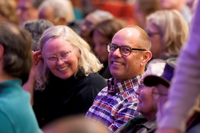 Closeup of audience members smiling from the Main Floor