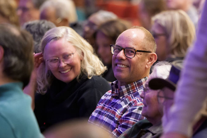 Closeup of audience members smiling from the Main Floor