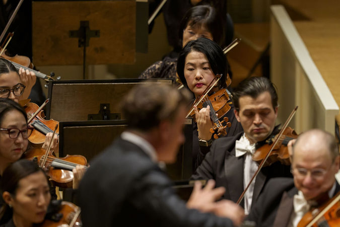 Closeup action shot of CSO violin Rong-Yan Tang on stage