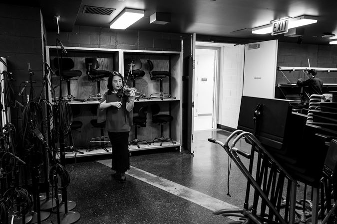 CSO violin Yuan-Qing Yu warming up backstage
