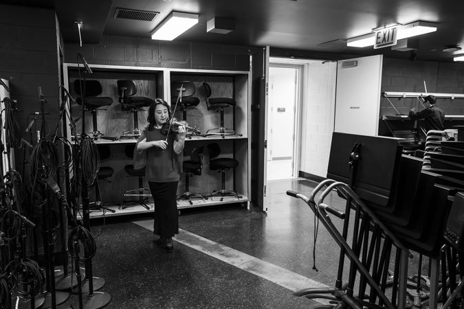 CSO violin Yuan-Qing Yu warming up backstage