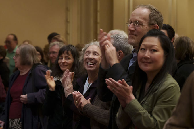 Audience members clapping on the main floor