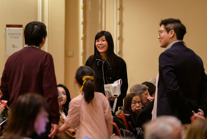Patrons smiling and conversing on the main floor in Orchestra Hall