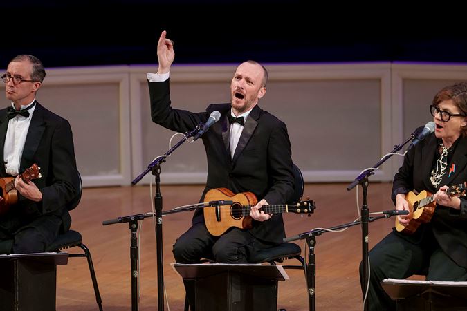 ensemble member Ben Rouse sings and strums