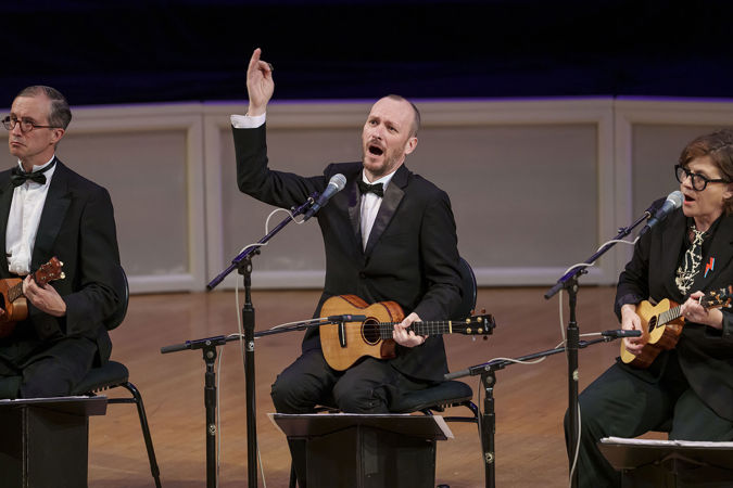 ensemble member Ben Rouse sings and strums