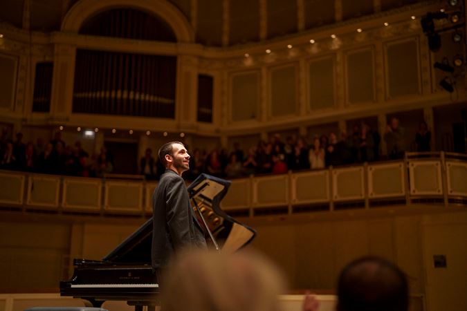 Alexandre Kantorow looking up to the audience from on stage