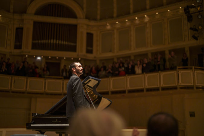 Alexandre Kantorow looking up to the audience from on stage