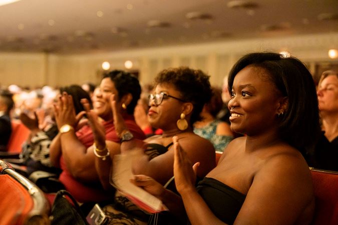 a trio of young audience members on the main floor claps enthusiastically as Brad and Christian are introduced
