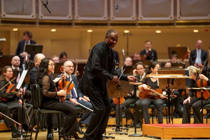 Closeup of guest conductor Thomas Wilkins speaking with Chicagoland students in the audience