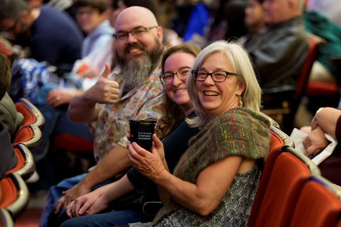 audience members smile and give a thumbs up before the concert